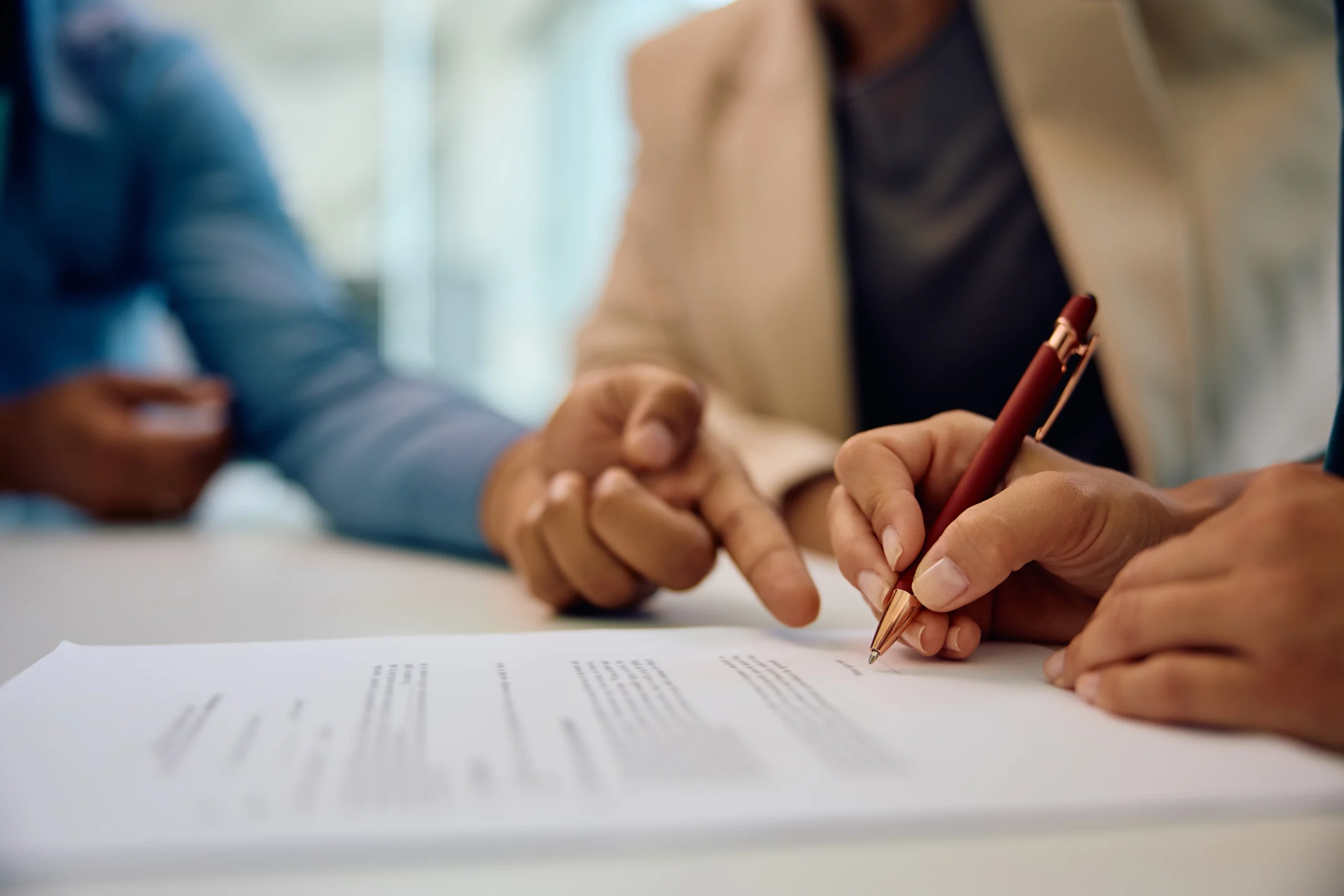 Business professionals reviewing and signing documents, illustrating how Chapter 7 bankruptcy can affect co-signers in Oregon.