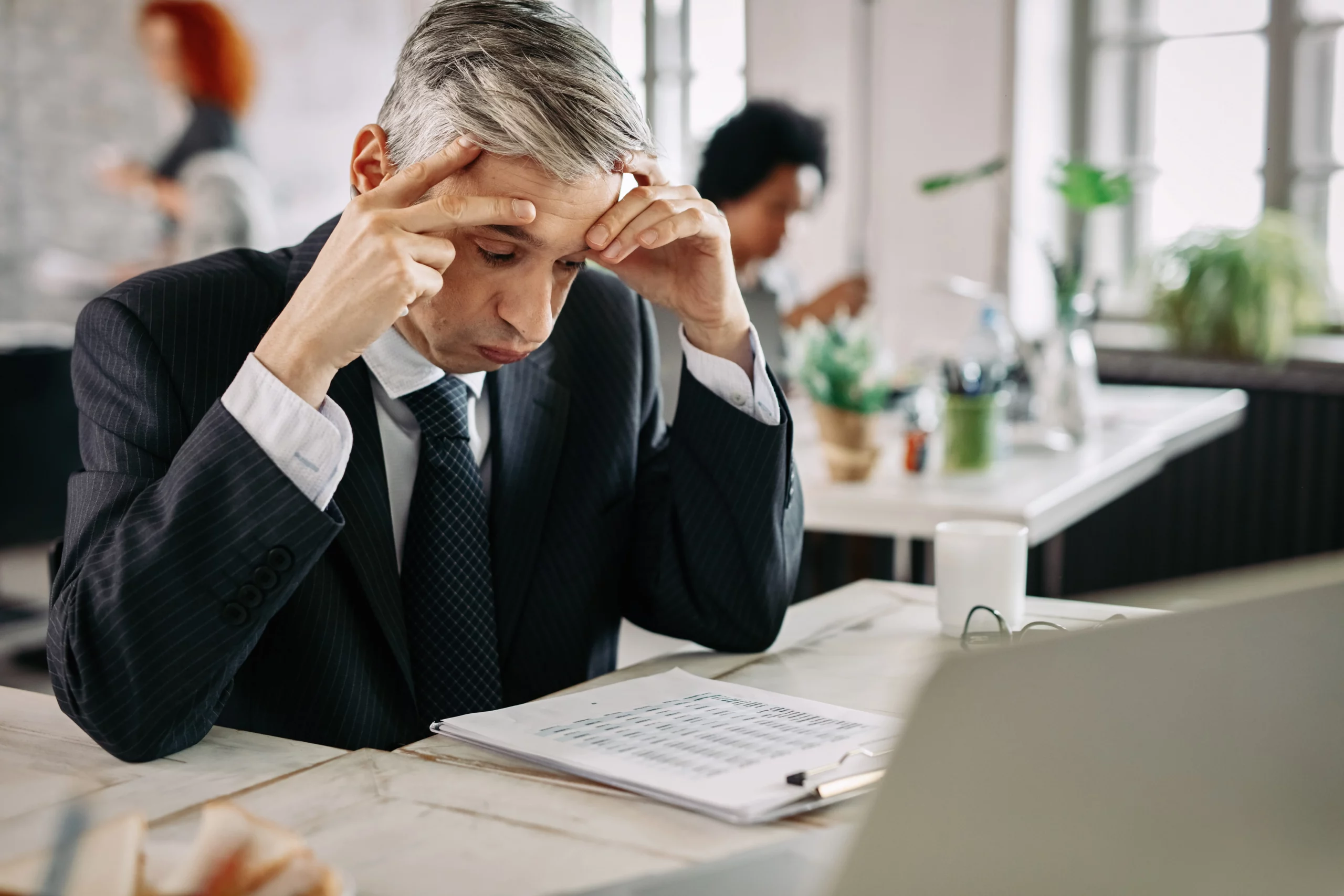 Stressed businessman reviewing paperwork, illustrating concerns about protecting a 401(k) during Chapter 13 bankruptcy in Oregon.