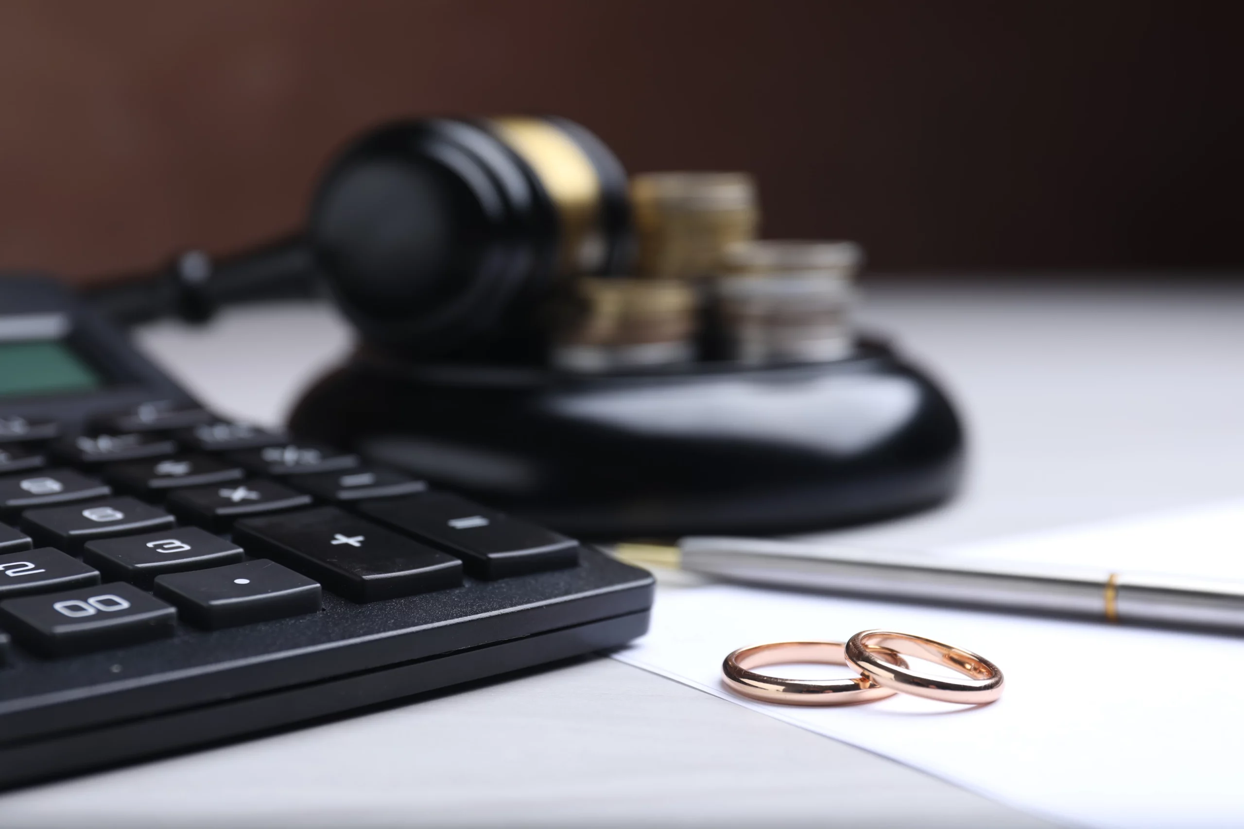 Judge’s gavel, financial documents, and wedding rings illustrating whether to file bankruptcy before or after divorce in Oregon.